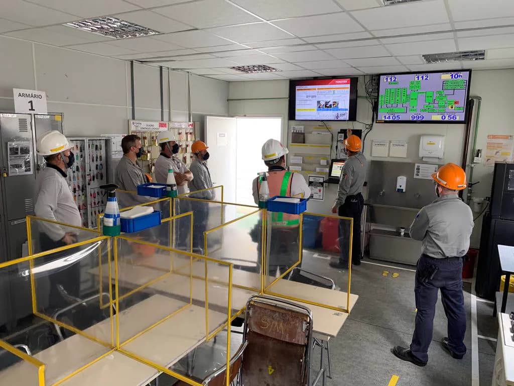 Equipe industrial acompanhando informações de manutenção em painéis de gestão visual