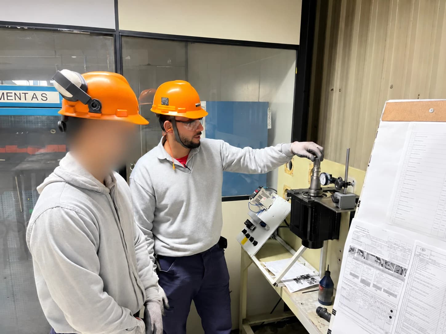 Profissional orientando a verificação de um componente junto ao equipamento